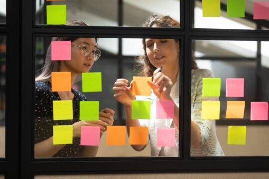 two women working with stickie notes