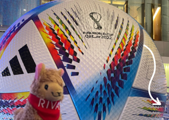 stuffed alpaca in front of world cup ball in Qatar